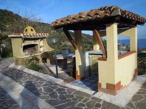 a gazebo with a pizza oven on a patio at Appartamenti Con Vista Panoramica in Santa Maria Navarrese