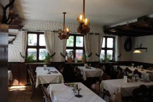 a dining room with tables and chairs and windows at Hotel Petzengarten in Nuremberg