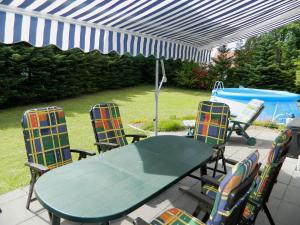 a patio with a table and chairs and a pool at Landhaus Lüneburger Heide "Ferienhaus bis 6 Personen" in Neuenkirchen