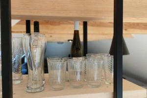 a group of glasses on a shelf with a bottle of wine at Hubane ja ruumikas katusealune majutus karjamõisa ajaloolises hoones in Plaani