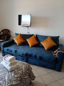 a blue couch with pillows and a television on the wall at Studio avec piscine Cabo Dream à Cabo négro in Cabo Negro