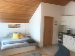 a small bedroom with a bed and a kitchen at Studio Central Grindelwald in Grindelwald
