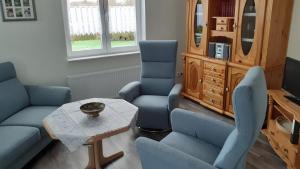 a living room with blue chairs and a table at Grosszügige Wohnung für 4 Personen in Ostfriesland mit E- Ladesäule in Utarp