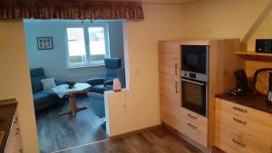 a living room with a blue couch and a tv at Grosszügige Wohnung für 4 Personen in Ostfriesland mit E- Ladesäule in Utarp