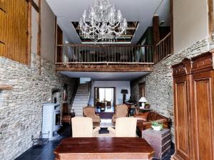 a living room with a staircase and a chandelier at Le Maissin 1876 in Paliseul