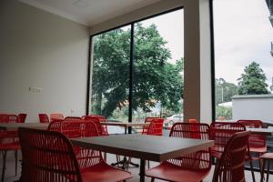 a room with tables and chairs and a large window at Scorpio Hotel Gonio in Gonio