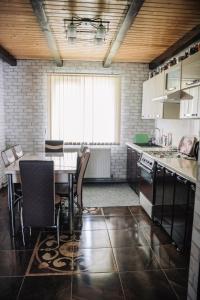 a kitchen with a table and chairs and a window at Стежка в гори in Verkhovyna