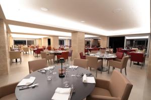 un restaurante con mesas y sillas y copas de vino en Kairos Resort & SPA, en Piedimonte San Germano
