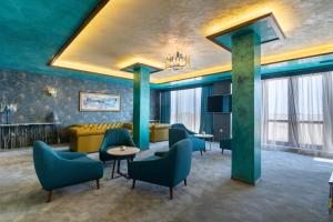 a hotel lobby with blue walls and chairs at Maria Palace Complex in Balchik