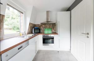a kitchen with white cabinets and a sink and a window at Rapunzel in Neuenbürg