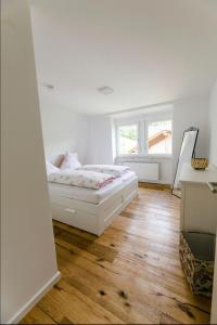 ein weißes Schlafzimmer mit einem Bett und einem Fenster in der Unterkunft Rapunzel in Neuenbürg