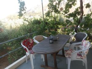 a wooden table and chairs on a balcony at Irene's studios in Panormos Kalymnos