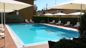 a large blue swimming pool with chairs and umbrellas at Albergo Ristorante Papa in Peschiera del Garda