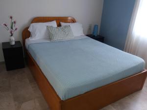 a bed with a wooden frame with a blue mattress at Irene's studios in Panormos Kalymnos