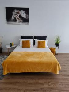 - une chambre avec un grand lit et une couverture jaune dans l'établissement Apartament Luca P4B Oradea Prima Residence, à Oradea