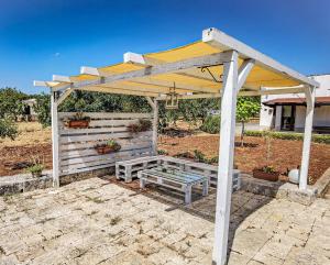 a picnic shelter with a bench under it at La corte del nonno by Itriahomes in Ceglie Messapica