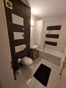 een badkamer met een toilet, een bad en een wastafel bij Garsoniera Zebra in Braşov