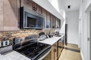 a kitchen with a stove and a microwave at Urban Paradise in OTR - Beautiful New Condo In Historic Building With Downtown Views! condo in Cincinnati