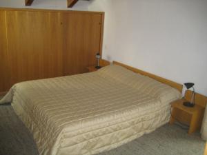 a bedroom with a bed and two lamps on tables at Appartamenti Decrestina in Campitello di Fassa