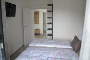 Un pequeño dormitorio con una cama y un televisor. en Apartment Uggowitzer, en Drobollach am Faakersee 13 fotos más