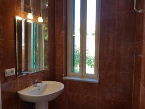 a bathroom with a sink and two windows at Albergo Santa Teresa in Torre del Greco