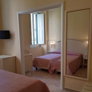 1 dormitorio con 2 camas y un espejo grande en Albergo Santa Teresa en Torre del Greco