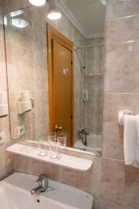 a bathroom with a sink and a mirror at Hotel Ría de Suances in Suances
