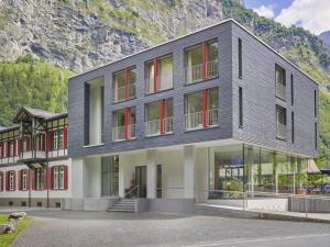 a building with red windows and a mountain at Hotel Tödi in Linthal