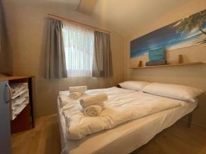 1 dormitorio con 2 camas y toallas. en Dalmacia mobile homes and caravans at the beach, en Privlaka