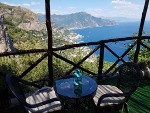 una mesa y sillas con vistas al océano en La Casetta Nel Bosco, Amalfi, en Amalfi