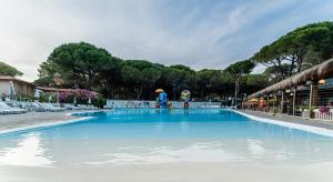 una grande piscina blu in un resort di Arcobaleno Village a Marina di Bibbona