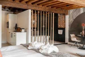 a bedroom with a white bed and a kitchen at Bossche Suites No2 - Verwersstraat in Den Bosch