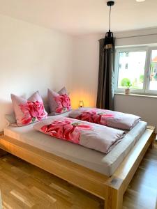 a bedroom with a large bed with pink pillows at Chiemsee Pferdehof Ferienwohnungen in Bernau am Chiemsee