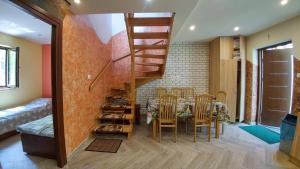 a dining room with a table and chairs and a staircase at Cypla Czar in Polańczyk