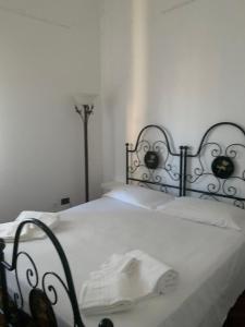 a bedroom with a white bed with a black headboard at Altrove in Cagliari