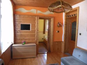 uma sala de estar com paredes cor de laranja e uma televisão em Hotel Lesní dům em Janske Lazne