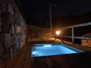 a swimming pool in the middle of a patio at night at Casa do Ti Toninho in Coimbra