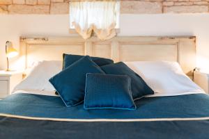 a bed with blue and white pillows on it at Palazzo Scotto in Alberobello