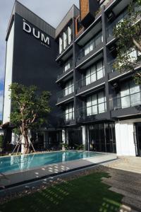 - un bâtiment avec une piscine en face dans l'établissement DUM Hotel - Si Phum, à Chiang Mai