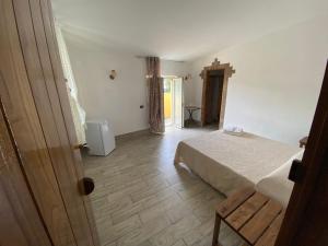 La Casa di Michele في تريكينا: غرفة نوم بسرير وارضية خشبية