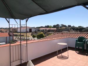 balcón con sillas y vistas a la ciudad en Hostal La Caballeriza, en Malpartida de Cáceres