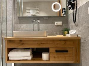 a bathroom vanity with a sink and a mirror at Pension Eberharter in Mayrhofen