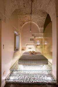 una camera da letto con un grande letto in una stanza grande di Palazzo Scotto ad Alberobello