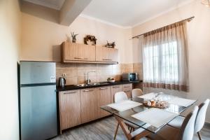 a kitchen with a table and a refrigerator at Potamos Apartments in Sidari