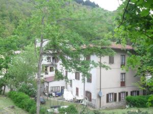 ein großes weißes Gebäude mit Bäumen davor in der Unterkunft Albergo Giardino in Badia Prataglia
