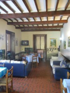 a living room with blue couches and a table at Albergo Giardino in Badia Prataglia