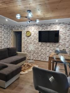 a living room with a couch and a tv on a brick wall at Hannah in Krāslava