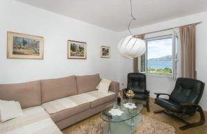 ein Wohnzimmer mit einem Sofa und 2 Stühlen in der Unterkunft Apartments Maria in Koločep