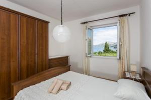 a bedroom with a large bed with a window at Apartments Maria in Koločep