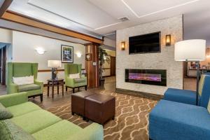 a living room with a fireplace and a tv at Comfort Inn Williamsport in Williamsport